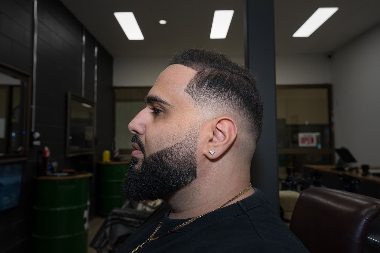 Client in profile with a full beard and fade