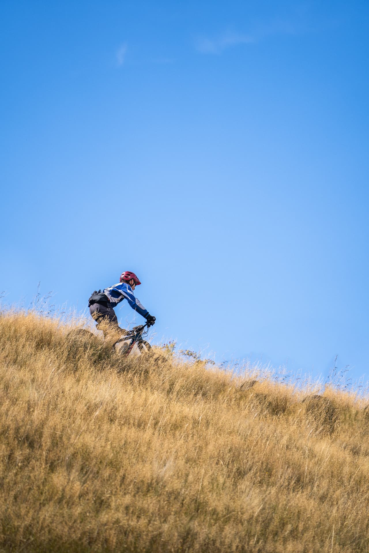 Lone rider on a ridgeline under a clear sky