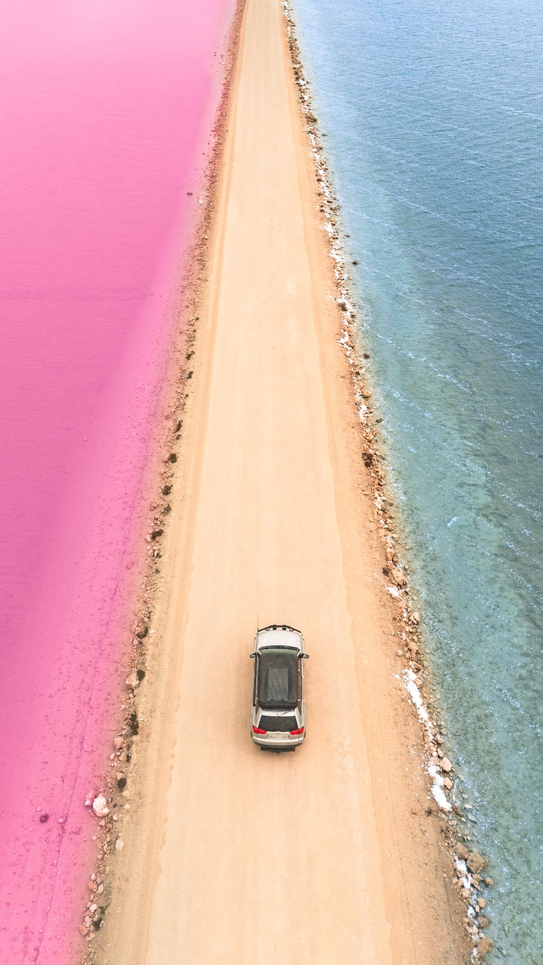 Aerial view of a pink lake beside the ocean road